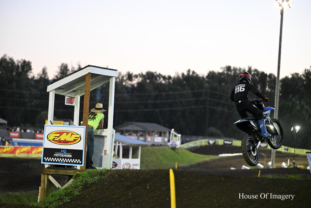 Motocross Motorcyclist makes jump under the lights: Motorsports Photography